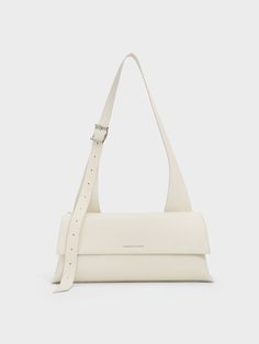 This product is made with at least 20% sustainable materials by weight. CHARLES & KEITH uses recycled, degradable, organic, and water-based materials in our eco-conscious collection. A polished bag in chic cream is the perfect accessory for summer and beyond. With an elongated trapeze silhouette and an elongated shoulder handle -- which can be adjusted to suit your preferred drop length -- this clean and sleek design will complement any outfit of your choice, from flowy dresses to casual denim looks. Fitted with a magnetic closure, it opens up to an spacious inner compartment -- thanks to the the horizontal silhouette of this bag, it will easily hold your daily essentials and then some. Trapeze Silhouette, Trapeze Bag, Flowy Dresses, Pretty Bags, Charles Keith, Eco Conscious, Sustainable Materials, Casual Denim, Kids Gifts