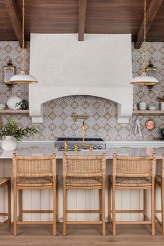 a kitchen with an oven, counter top and chairs in front of the stovetop