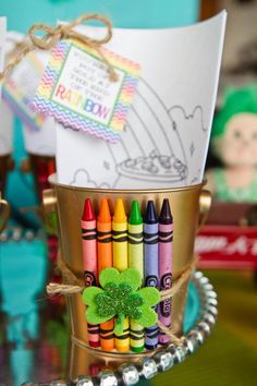 there are crayons in the bucket on the table with a card and other items