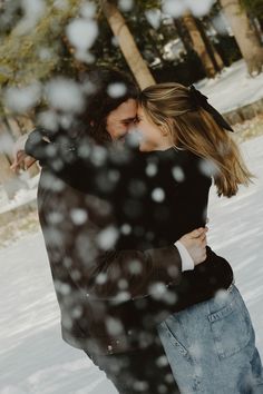 a man and woman hugging in the snow