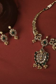 This stunning silver hasli necklace showcases intricate nakshi designs that accentuate timeless Indian floral and ivy patterns. At the pinnacle of the necklace sits a statue of Lord Balaji, adding to its allure. The charm of this exceptional vintage collar necklace is further enhanced by the dangling cluster of rice pearls, making it a definite head-turner. Elegant Necklace With Intricate Design For Navratri, Traditional Necklaces For Diwali, Antique Kundan Temple Necklace For Diwali, Antique Chandbali Temple Necklace For Diwali, Antique Heavy Temple Necklace For Diwali, Oxidized Finish Necklace For Wedding And Navratri, Festive Kundan Temple Necklace With Oxidized Finish, Diwali Antique Tilla Kundan Necklace, Antique Kundan Chandbali Necklace With Intricate Design