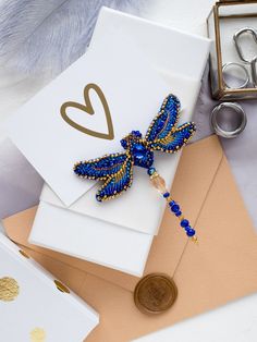 a card with a beaded butterfly on it next to some scissors and other items