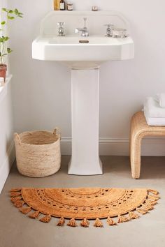 a white pedestal sink sitting next to a bath tub