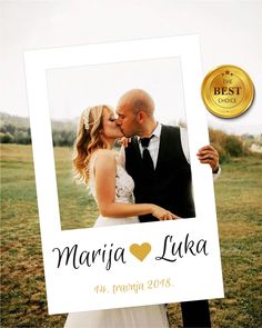 a man and woman kissing each other in front of a photo frame with a gold medal