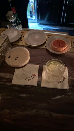 plates and bowls on a counter top with watermelon