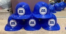 several blue hard hats are stacked on top of each other