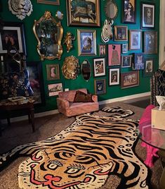 a living room with green walls and pictures on the wall, including a tiger rug