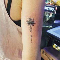 a woman's arm with a tattoo on it that has a flower in the middle