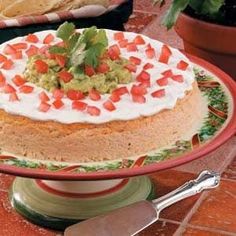 a cake on a platter with guacamole and salsa in the middle