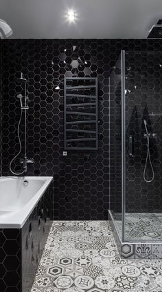 a bathroom with black and white tiles on the walls, flooring and bathtub