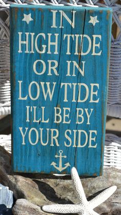 a wooden sign that says in high tide or low tide i'll be by your side