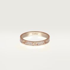 an 18k rose gold ring with diamonds on the sides and a name engraved on the side