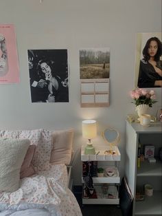 a bedroom with pictures on the wall and a small bed in front of a night stand