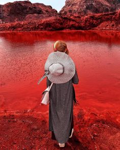 a woman standing in front of a red lake