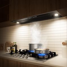 a stove top with pots and pans on it in a kitchen next to a bottle of wine