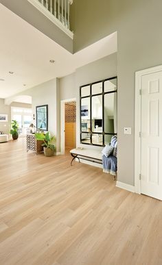 a living room with hard wood flooring and white trim on the walls is shown