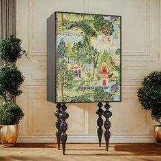 an art piece on display in a room with potted plants and other decor items