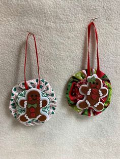 two ornaments are hanging on the wall next to each other, decorated with gingerbreads