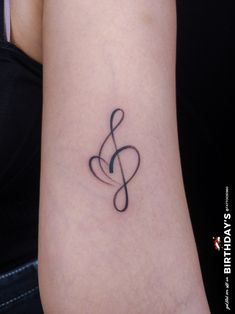 a woman's arm with a musical note tattoo on the left side of her arm