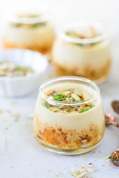 three desserts in small glass jars on a table