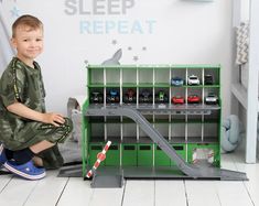 a little boy that is sitting on the floor with a toy car set in front of him