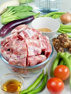 raw meat in a bowl surrounded by vegetables