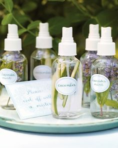 several bottles with flowers in them sitting on a table next to some cards and labels