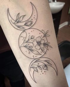 a woman's arm with three phases of the moon and flower