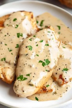 some chicken covered in gravy on a white plate