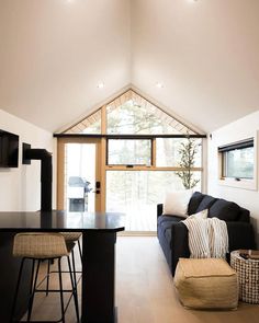 a living room filled with furniture next to a kitchen