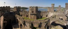 an aerial view of a castle with water in the background