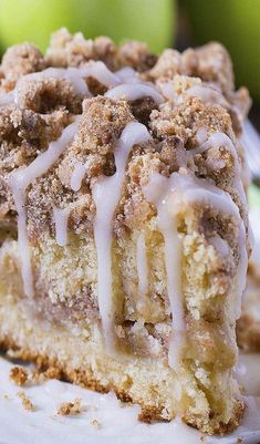 a close up of a piece of cake on a plate with apples in the background