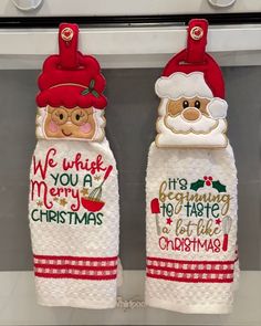 two christmas towels hanging from the front of an oven with santa claus on them and we wish you a merry christmas