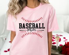 a woman wearing a pink baseball mom t - shirt with red roses in the background