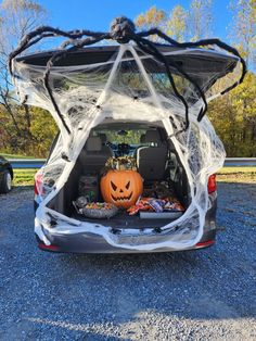 the trunk of a car decorated for halloween with spider web and jack o lantern decorations