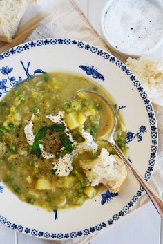 a bowl of soup with bread on the side