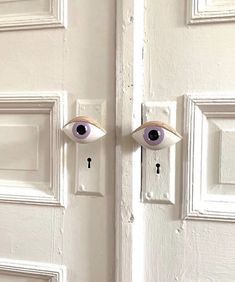 the door is painted white with two eyes and one keyhole on it's side