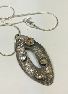 "Reticulated sterling silver necklace with 3 silver \"pods\" each filled with a dot of 14K gold. Enhanced with a small aquamarine set in a sterling silver bezel. The oval shaped pendant is 1 3/4\" long and 3/4\" at its widest point. The pendant hangs from an 18\" snake chain with a lobster claw catch. The pendant has been oxidized and hand finished to enhance the texture detail." Reticulated Silver Jewelry, Aquamarine Necklace, Sterling Silver Necklace, Snake Chain, Lobster Claw, Sterling Silver Necklaces, Aquamarine, Necklace Etsy, Silver Gold