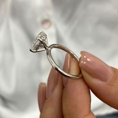 a person holding a diamond ring in their hand