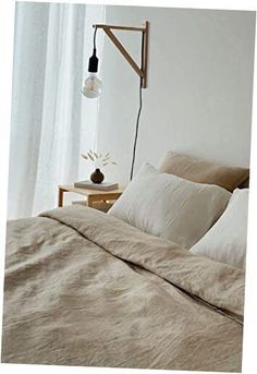 a bed with two pillows and a lamp on the side table in front of it