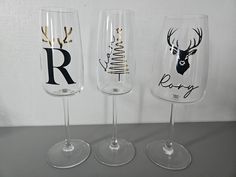 three wine glasses with different designs on them