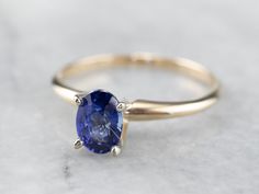 This is a classic engagement ring with clean lines and great proportions! This ring is quite traditional, featuring a solid gold head to hold the stone securely. Polished yellow gold shoulders complete the simple look. We've set this versatile piece with an intense sapphire, an exquisite cornflower blue that is bright and shining. The value of this gem is found in its quality - this is a benchmark gem, of the ultimate color and clarity that other sapphires can be compared against. Metal: 14K Yel Classic Oval Sapphire Ring, Classic Sapphire Halo Ring, Classic Sapphire Birthstone Ring, Classic Solitaire Sapphire Ring, Classic White Gold Solitaire Sapphire Ring, Classic Solitaire White Gold Sapphire Ring, Timeless Formal Solitaire Sapphire Ring, Classic Oval Sapphire Ring With Tension Setting, Classic Round Sapphire Solitaire Ring