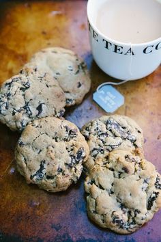 four cookies and a cup of tea on a table