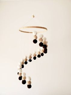 a wind chime hanging from the ceiling in a room with white and black balls