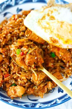 a blue and white plate topped with rice and meat