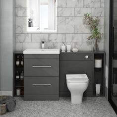 a white toilet sitting next to a sink in a bathroom under a mirror above a window