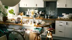 a kitchen filled with lots of clutter and furniture