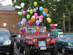 a jeep with balloons attached to the hood