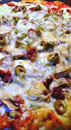 a pizza with cheese, olives and mushrooms on it