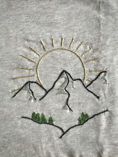 the sun is shining over mountains with trees on each side and two small hills in the middle